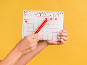Lápis apontando para um calendário com a intenção de mostrar se é possível engravidar fora do período fértil.