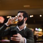 Homem tomando bebida alcoólica e se perguntando se álcool e fertilidade masculina têm alguma relação.