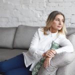 Mulher na fase de perimenopausa, sentada, pensando sobre a possibilidade de engravidar.