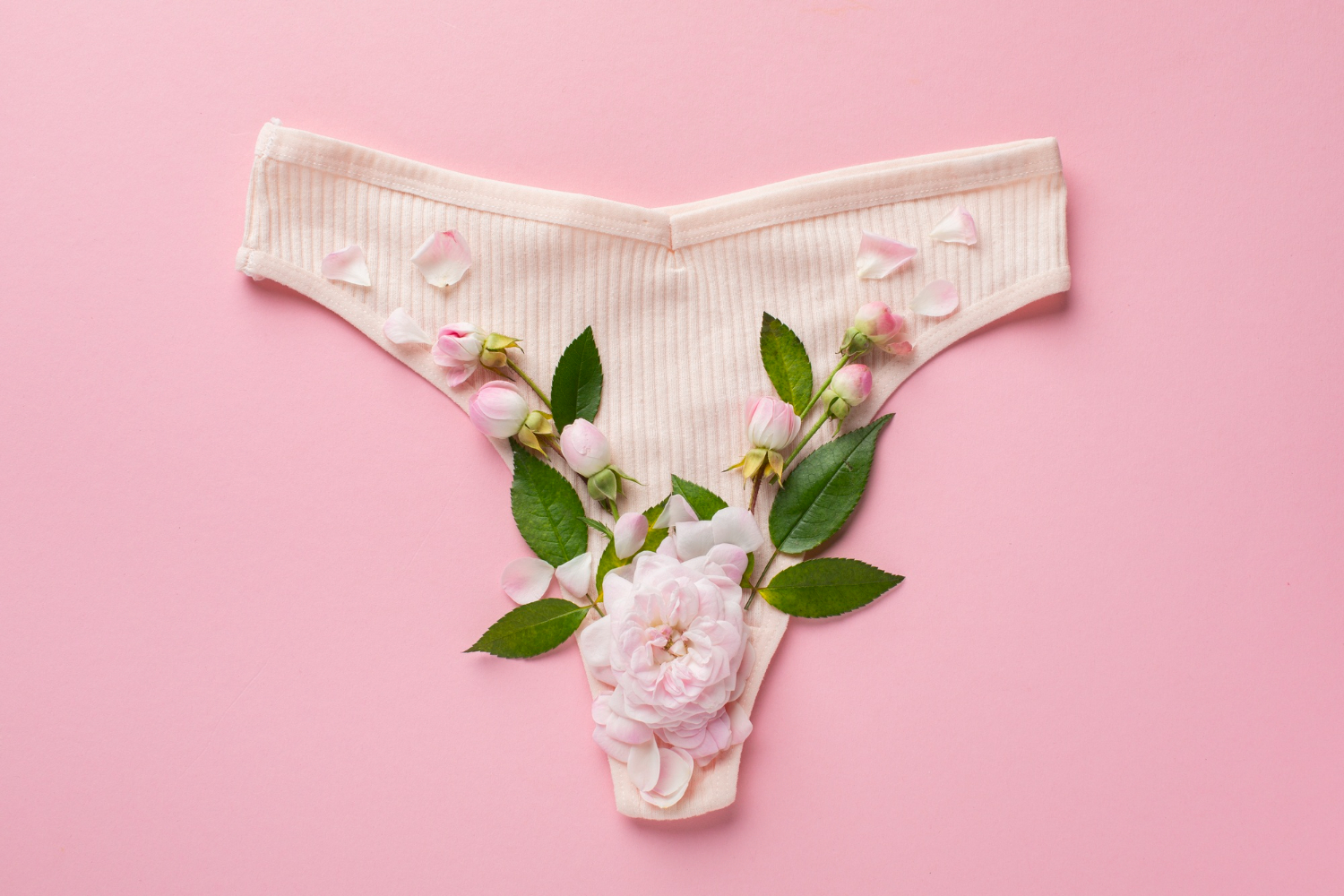 Foto de uma calcinha com algumas flores no fundo, representando o muco cervical.