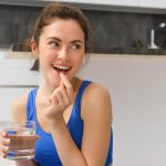 Mulher tomando ácido fólico para engravidar, após recomendação médica.