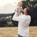 Homem segurando um bebê nos braços, demonstrando que homens trans podem engravidar