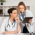 Médicas olhando para o tablet e discutindo qual o melhor tratamento para engravidar com SOP.