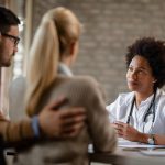 Casal em frente à medica em consulta para tentar a segunda FIV.