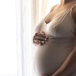Mulher de 40 anos segurando a barriga grávida para representar a pergunta: qual a idade máxima para fazer inseminação artificial