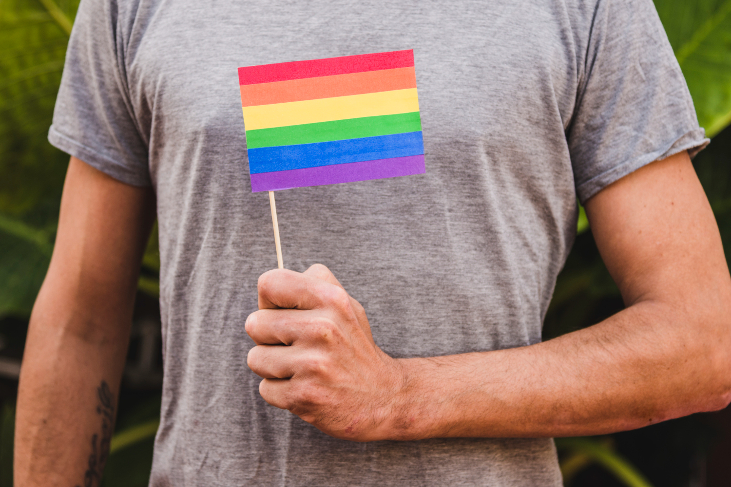 Homem segurando a bandeira LGBT para representar a preservação da fertilidade em pessoas transgênero
