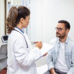 Médica especialista em reprodução humana explicando para paciente com câncer sobre oncofertilidade masculina.