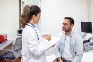 Médica especialista em reprodução humana explicando para paciente com câncer sobre oncofertilidade masculina.