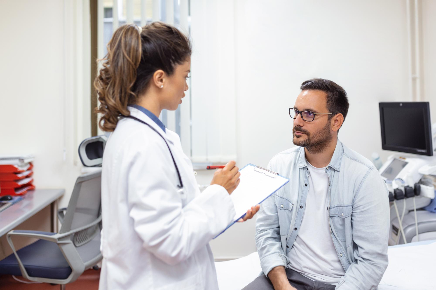 Médica especialista em reprodução humana explicando para paciente com câncer sobre oncofertilidade masculina.