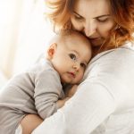 Mãe solo com bebê no colo após passar por tratamento de reprodução assistida