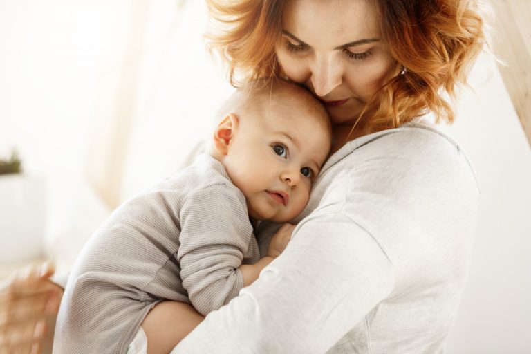 Mãe solo com bebê no colo após passar por tratamento de reprodução assistida