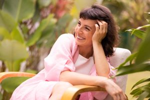Mulher sentada sorrindo após descobrir como preservar a fertilidade com o congelamento de óvulos