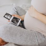 Mulher grávida segurando uma foto do ultrassom para representar os mitos e verdades sobre inseminação artificial