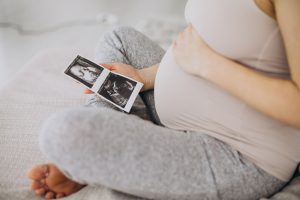 Mulher grávida segurando uma foto do ultrassom para representar os mitos e verdades sobre inseminação artificial
