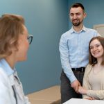 Médica explicando a um casal as etapas do aconselhamento genético