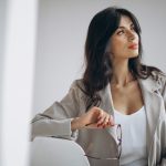 Mulher encostada na parede pensando se deve congelar óvulos ou não