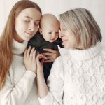 Duas mulheres segurando um bebê após optarem pelo método ROPA.