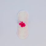Imagem ilustrativa de um absorvente com uma flor para abordar quando o sangramento após a FIV é normal.