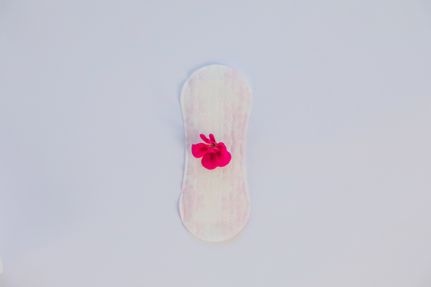 Imagem ilustrativa de um absorvente com uma flor para abordar quando o sangramento após a FIV é normal.