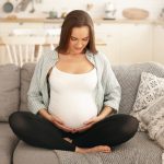 Gestante olhando para a barriga depois de engravidar com óvulos congelados