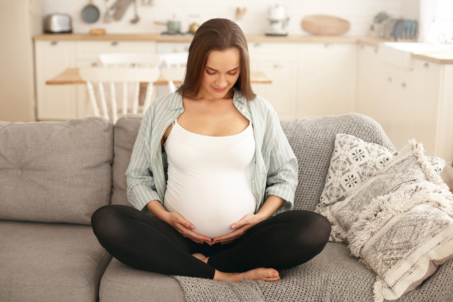 Gestante olhando para a barriga depois de engravidar com óvulos congelados