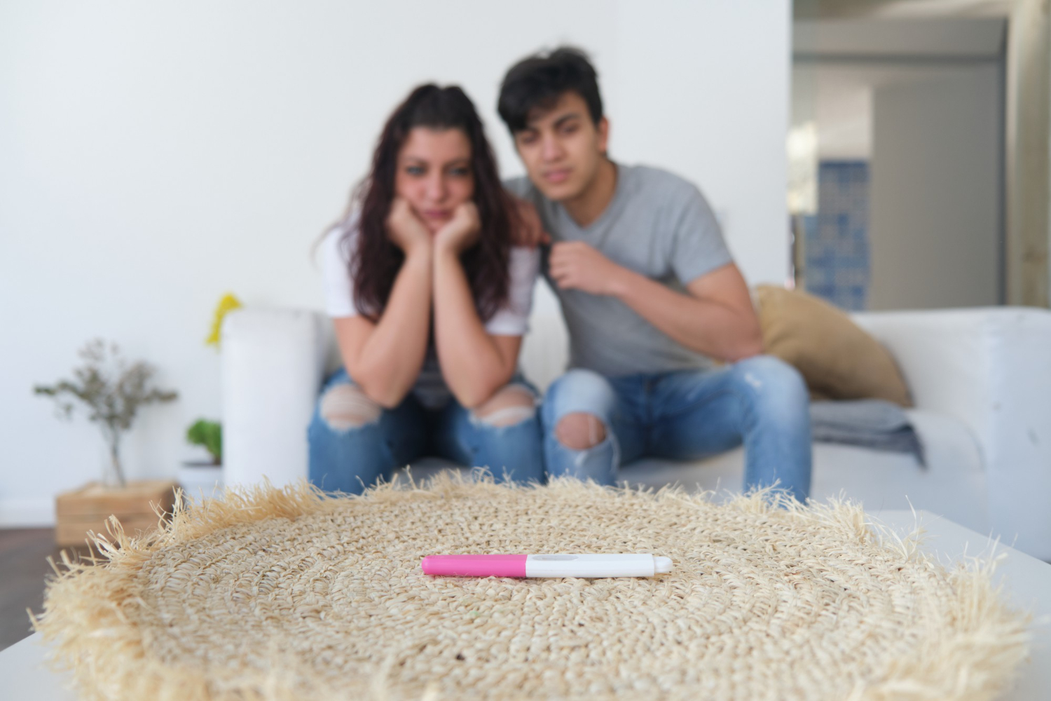 Casal que não consegue engravidar olhando triste para o teste de gravidez.