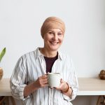 Mulher que está passando pelo tratamento de câncer sorrindo porque optou pela oncopreservação.